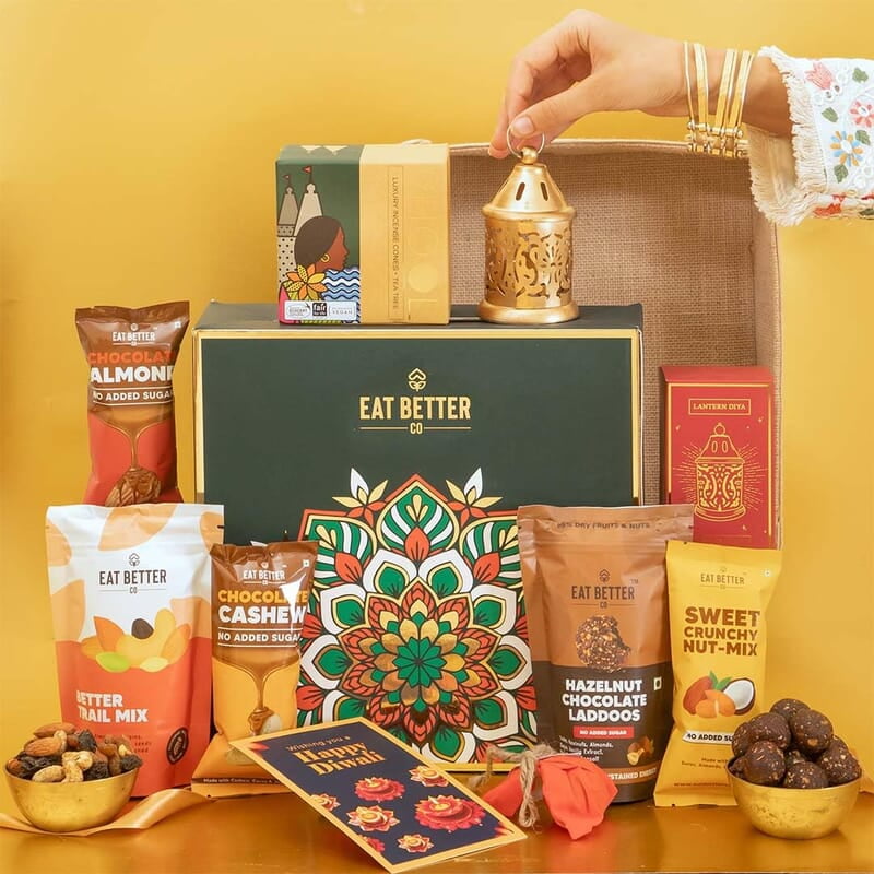 Eat Better Co Prakriti Diwali Gift Hamper with Jute Tray - 10 Item Gift Pack - Dry Fruits Laddoo, Chocolate Coated Nuts with Phool Incense Cones & Lanten Diya | Diwali Gift Box for Friends & Family Eat Better Co Prakriti Diwali Gift Hamper with Jute Tray - 10 Item Gift Pack - Dry Fruits Laddoo, Chocolate Coated Nuts with Phool Incense Cones & Lanten Diya | Diwali Gift Box for Friends & Family