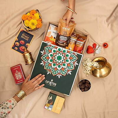 Eat Better Co Prakriti Diwali Gift Hamper with Jute Tray - 10 Item Gift Pack - Dry Fruits Laddoo, Chocolate Coated Nuts with Phool Incense Cones & Lanten Diya | Diwali Gift Box for Friends & Family Eat Better Co Prakriti Diwali Gift Hamper with Jute Tray - 10 Item Gift Pack - Dry Fruits Laddoo, Chocolate Coated Nuts with Phool Incense Cones & Lanten Diya | Diwali Gift Box for Friends & Family
